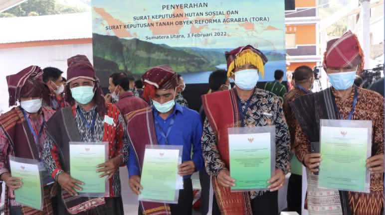En 2022, le président Joko Widodo a remis en personne les certificats de reconnaissance de forêt indigène aux habitants 5 hommes habillés en Batak présentent des certificats de reconnaissance de forêt indigène