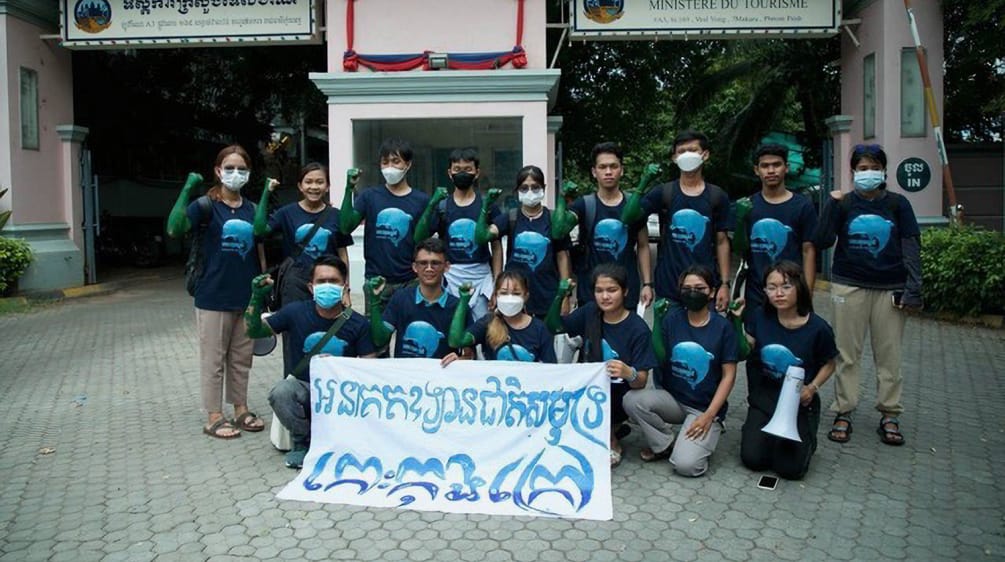 15 jeunes gens sont debout et agenouillés devant le bâtiment du ministère du Tourisme à Phnom Penh. Ils tiennent une bannière sur laquelle est écrit en cambodgien : "L’île de Koh Kong doit devenir un parc national marin"