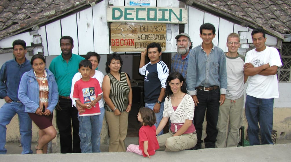 Groupe de membres des organisations DECOIN et Sauvons la forêt devant une cabane en bois dans la région de l’Intag en Equateur