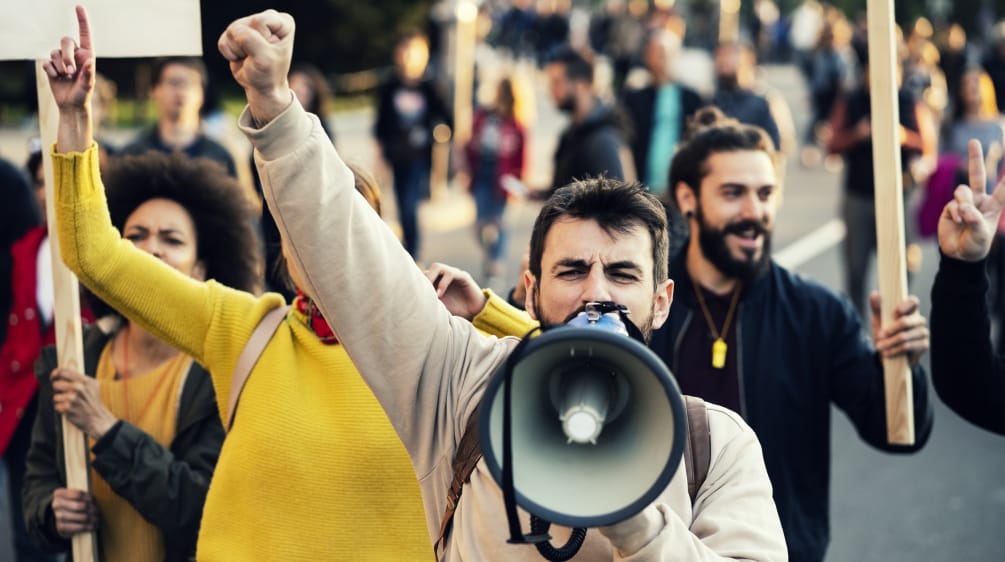 Homme hurlant dans un mégaphone lors d’une manifestation