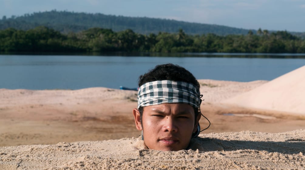 Activiste dont seule la tête dépasse hors du sable