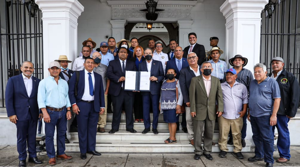 Un groupe d’une vingtaine de personnes entoure le président du Panama sur le perron du palais présidentiel pour présenter la loi signée