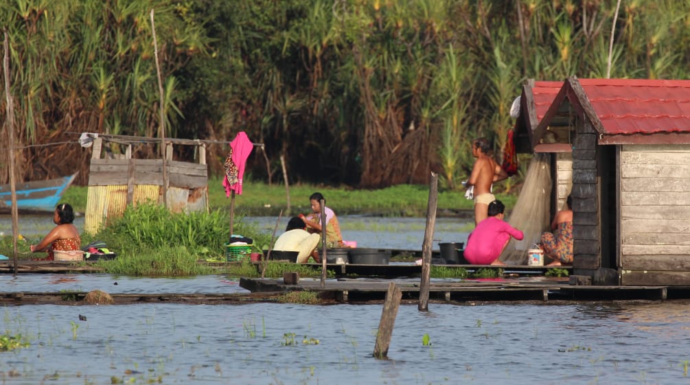 La vie sur les rives du lac Sembuluh – des femmes lavent du linge, accroupies sur des passerelles