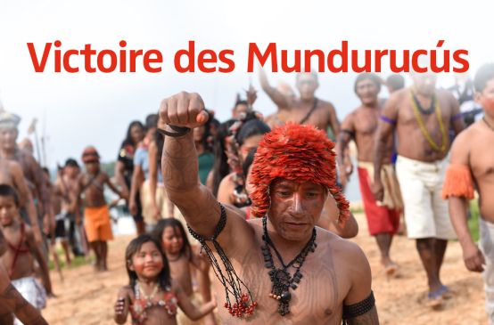 Les Mundurucús manifestent. Au premier plan, un Indien tatoué le point levé.