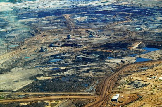 Vue aérienne sur un site d’extraction des sables bitumineux dans la région de l’Alberta au Canada. Les forêts boréales ont disparu, laissant la place à un paysage apocalyptique.