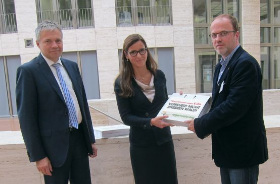 Guido Knott (à gauche) et Anette Bickmeyer (au milieu) du groupe E.On reçoivent des mains de Matthias Fischer (à droite) la pétition de Sauvons la forêt et ses presque 114 000 signatures