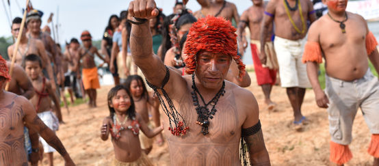 Les Mundurucús manifestent. Au premier plan, un Indien tatoué le point levé.