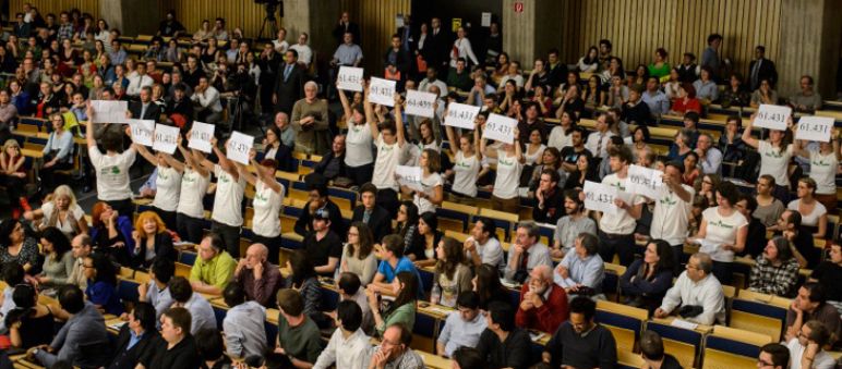 Nous avons montré au président Correa le rejet à l'échelle mondiale qu'inspire son projet d'extraction de cuivre dans les forêts de l'Intag Vue plongeante sur l'amphithéâtre comble de l'université technique de Berlin. Debout, des activistes de Intag e.V. et Sauvons la forêt (Rettet den Regenwald) brandissent ensemble les pancartes floquées du nombre 61.431