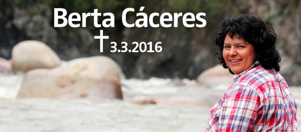 Assise sur un rocher au bord d’un torrent, l’activiste écologiste Berta Cáceres - assassinée chez elle le 3 mars 2016 - de profil nous regarde souriante par-dessus son épaule