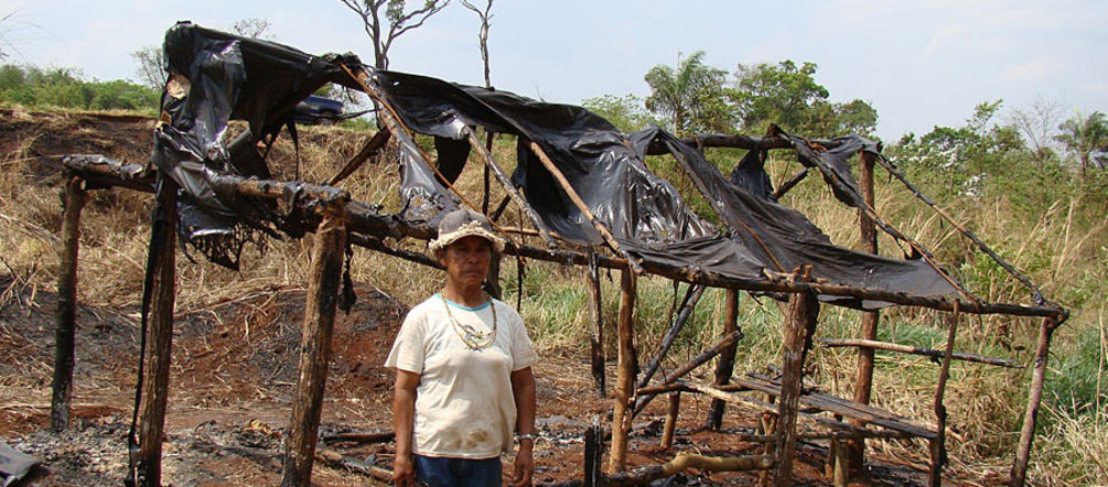 Damiana, Guaraní-Kaiowá et guide spirituelle Apyka'y, devant une hutte calcinée pendant les expulsions