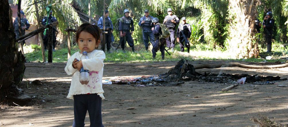 Les familles paysannes sont les premières victimes de l'huile de palme Petite fille effrayée (au premier plan) par les paramilitaires armés (à l'arrière plan)