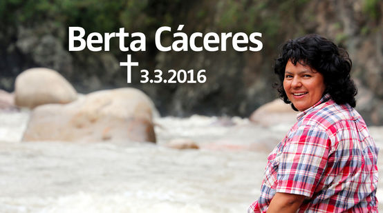 Assise sur un rocher au bord d’un torrent, l’activiste écologiste Berta Cáceres - assassinée chez elle le 3 mars 2016 - de profil nous regarde souriante par-dessus son épaule