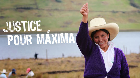 Avec ses terres et le lagon bleu en arrière plan, Máxima Acuña de Chaupe,  coiffée du chapeau traditionnel des agriculteurs péruviens nous salue le bras en l’air et le pouce tendu vers le ciel.