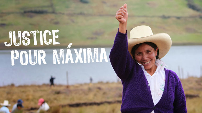 Avec ses terres et le lagon bleu en arrière plan, Máxima Acuña de Chaupe,  coiffée du chapeau traditionnel des agriculteurs péruviens nous salue le bras en l’air et le pouce tendu vers le ciel.