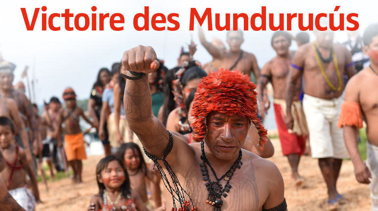 Les Mundurucús manifestent. Au premier plan, un Indien tatoué le point levé.