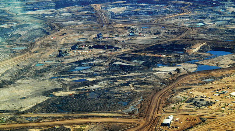 Vue aérienne sur un site d’extraction des sables bitumineux dans la région de l’Alberta au Canada. Les forêts boréales ont disparu, laissant la place à un paysage apocalyptique.