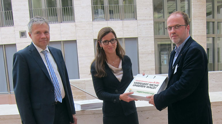 Guido Knott (g.) et Anette Bickmeyer réceptionnent près de 114.000 signatures contre le projet d’E.On Guido Knott (à gauche) et Anette Bickmeyer (au milieu) du groupe E.On reçoivent des mains de Matthias Fischer (à droite) la pétition de Sauvons la forêt et ses presque 114 000 signatures